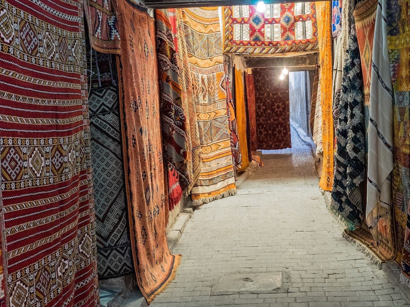 Moroccan rugs hanging along a market street